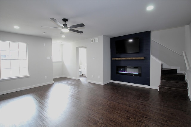 2202 Statler Dr, Carrollton, TX 75007 - unfurnished living room with a glass covered fireplace, dark wood-type flooring, ceiling fan, stairs, and recessed lighting