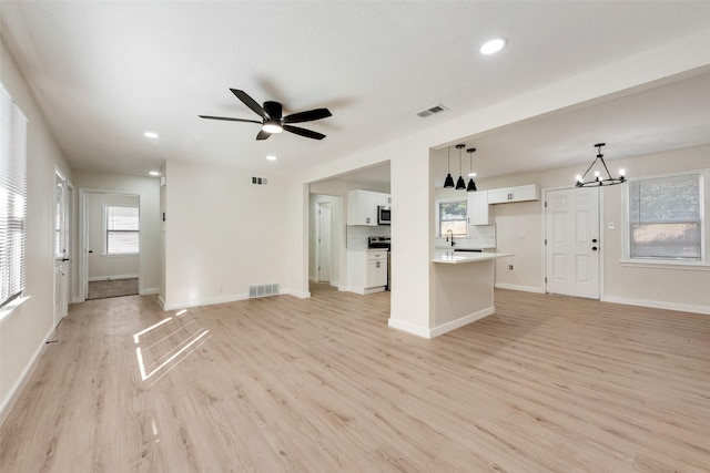 1628 Florence St, Arlington, TX 76010 - unfurnished living room with a chandelier, light wood-style flooring, ceiling fan, recessed lighting, and baseboards