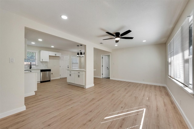 1628 Florence St, Arlington, TX 76010 - unfurnished living room with light wood finished floors, a chandelier, a ceiling fan, recessed lighting, and a sink