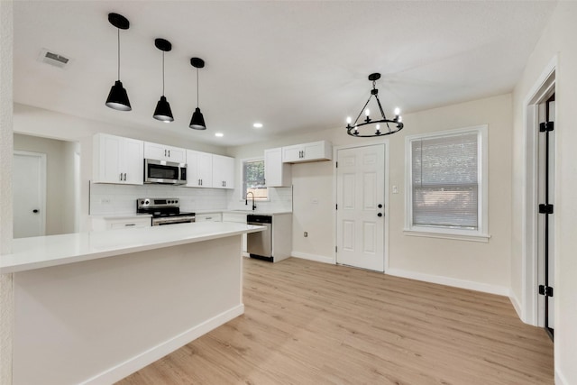 1628 Florence St, Arlington, TX 76010 - kitchen featuring appliances with stainless steel finishes, a sink, white cabinets, light wood finished floors, and recessed lighting