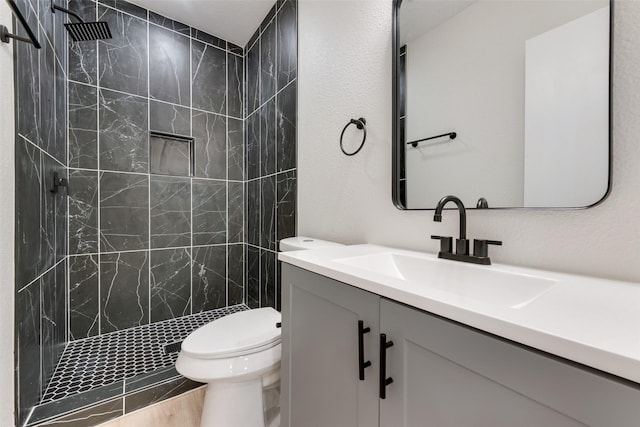1628 Florence St, Arlington, TX 76010 - full bathroom with vanity, a tile shower, and toilet