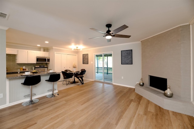 620 Admiralty Way, Fort Worth, TX 76108 - kitchen featuring stainless steel appliances, a breakfast bar, crown molding, white cabinets, and light wood finished floors