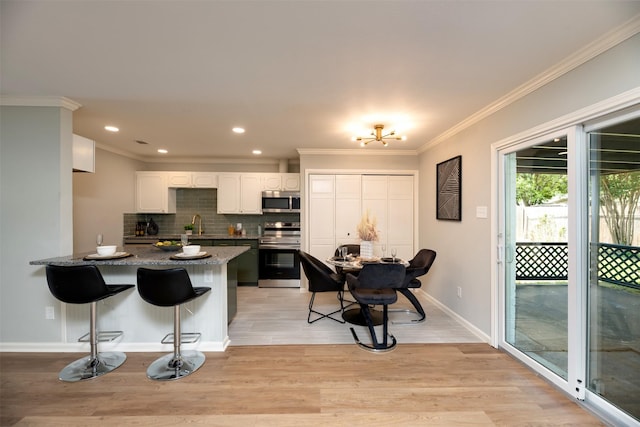 620 Admiralty Way, Fort Worth, TX 76108 - kitchen with appliances with stainless steel finishes, white cabinetry, a peninsula, backsplash, and a breakfast bar area