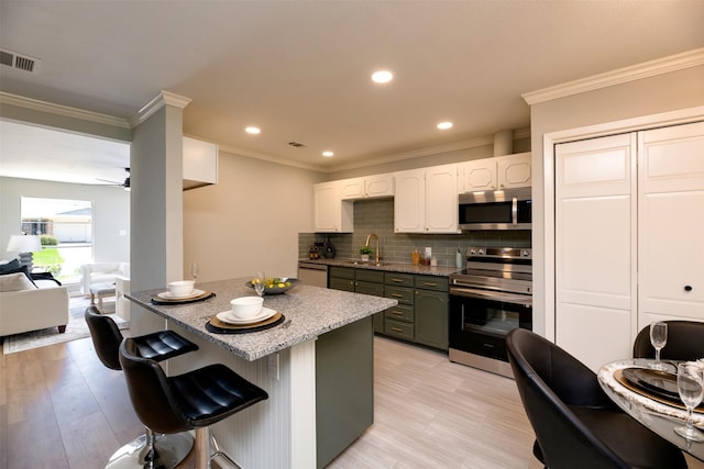 620 Admiralty Way, Fort Worth, TX 76108 - kitchen with stainless steel appliances, crown molding, backsplash, a sink, and a ceiling fan