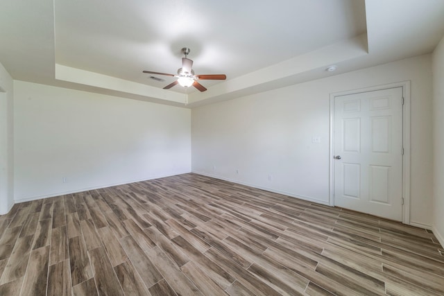 232 Lovers Path Dr, Springtown, TX 76082 - empty room featuring a tray ceiling, ceiling fan, wood finished floors, and baseboards