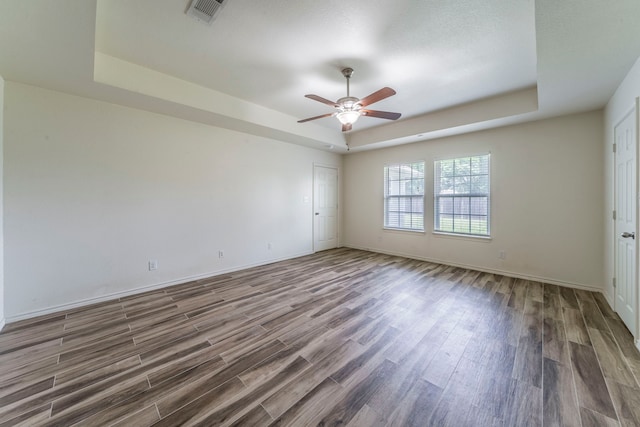 232 Lovers Path Dr, Springtown, TX 76082 - unfurnished room featuring a raised ceiling, wood finished floors, ceiling fan, and baseboards