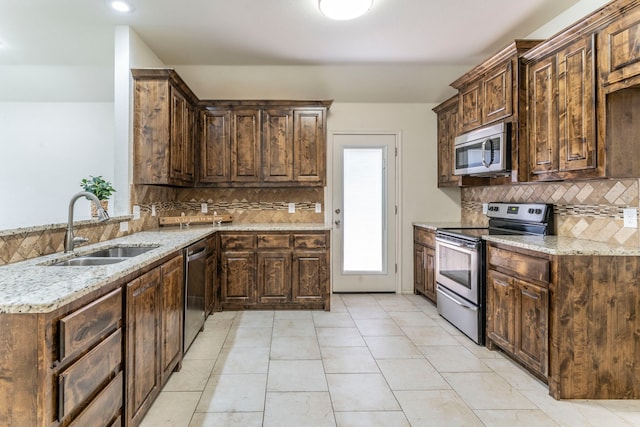 232 Lovers Path Dr, Springtown, TX 76082 - kitchen with stainless steel appliances, a sink, backsplash, and dark brown cabinets