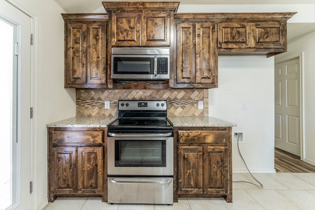 232 Lovers Path Dr, Springtown, TX 76082 - kitchen with stainless steel appliances, backsplash, light stone countertops, and dark brown cabinetry