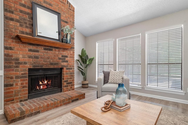 220 Timber Ridge Ln, Coppell, TX 75019 - living area with wood finished floors, a brick fireplace, a textured ceiling, baseboards, and lofted ceiling