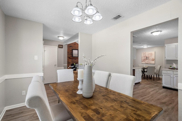 220 Timber Ridge Ln, Coppell, TX 75019 - dining space with wood finished floors, a textured ceiling, a chandelier, and baseboards