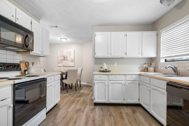 220 Timber Ridge Ln, Coppell, TX 75019 - kitchen with black appliances, a sink, light wood-style flooring, white cabinets, and a textured ceiling