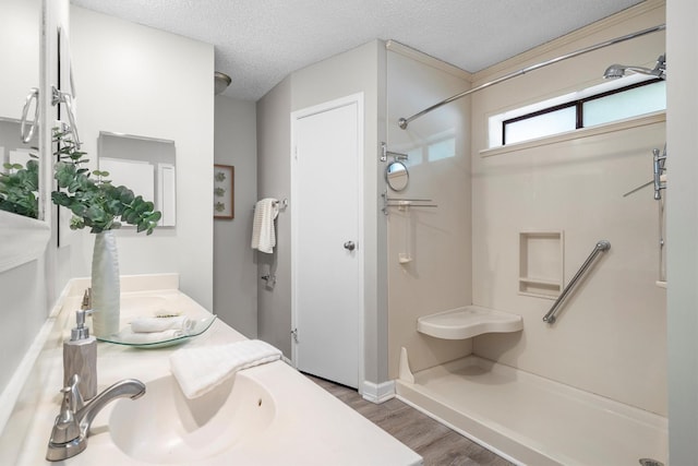 220 Timber Ridge Ln, Coppell, TX 75019 - bathroom featuring a shower, wood finished floors, a textured ceiling, vanity, and baseboards