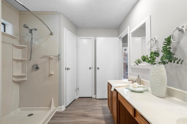 220 Timber Ridge Ln, Coppell, TX 75019 - bathroom with vanity, a textured ceiling, a shower, and wood finished floors