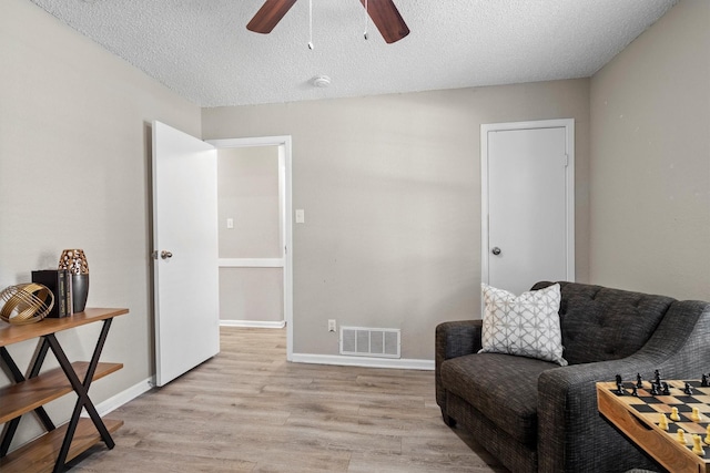 220 Timber Ridge Ln, Coppell, TX 75019 - living area featuring a ceiling fan, light wood finished floors, baseboards, and a textured ceiling