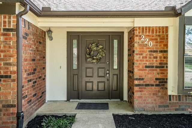 220 Timber Ridge Ln, Coppell, TX 75019 - view of exterior entry with brick siding and a shingled roof