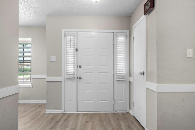 220 Timber Ridge Ln, Coppell, TX 75019 - entryway featuring wood finished floors, a textured ceiling, and baseboards