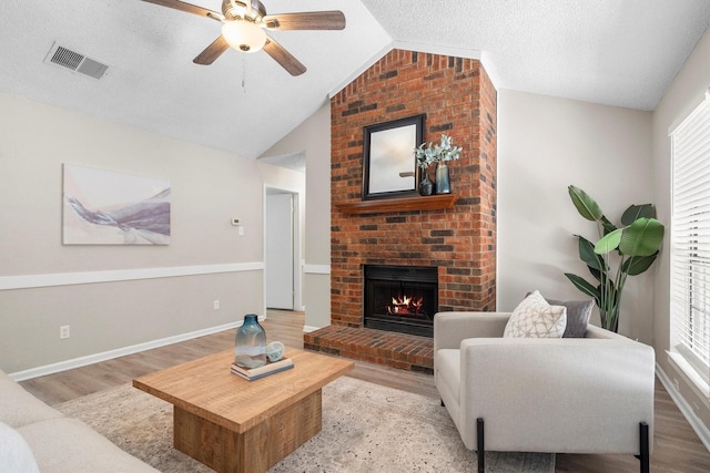 220 Timber Ridge Ln, Coppell, TX 75019 - living room with light wood finished floors, ceiling fan, vaulted ceiling, a brick fireplace, and baseboards