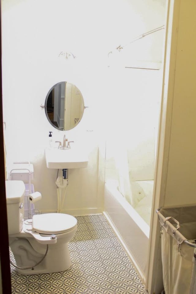 610 W 6th, Cisco, TX 76437 - bathroom featuring toilet, shower / tub combo with curtain, tile patterned floors, and a sink