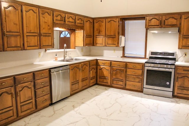 610 W 6th, Cisco, TX 76437 - kitchen with appliances with stainless steel finishes, under cabinet range hood, light marble finish flooring, light countertops, and a sink