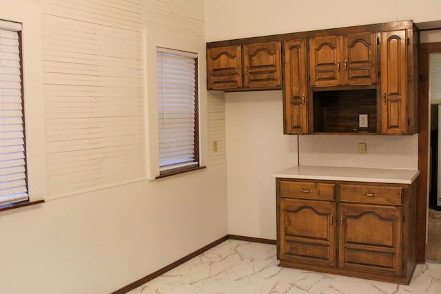 610 W 6th, Cisco, TX 76437 - kitchen featuring light marble finish flooring, light countertops, and baseboards