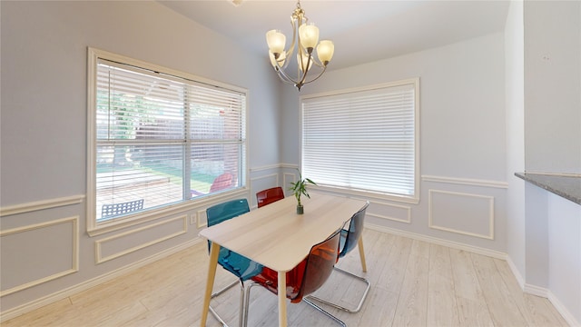 2801 Hereford Rd, Denton, TX 76210 - dining room with a chandelier, light wood-style flooring, a wainscoted wall, and a decorative wall