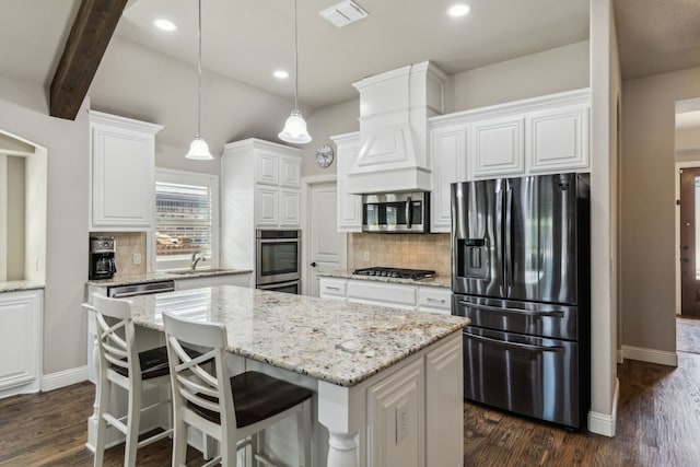4328 Waterstone Rd, Fort Worth, TX 76244 - kitchen with stainless steel appliances, white cabinets, a center island, backsplash, and dark wood-type flooring
