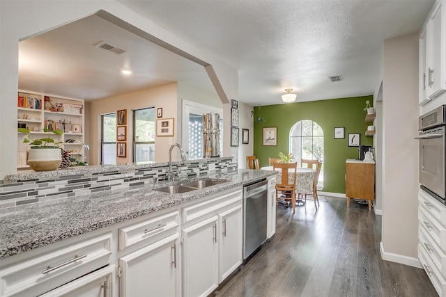 6325 Wallingford Dr, Fort Worth, TX 76133 - kitchen featuring a sink, stainless steel appliances, white cabinets, light stone counters, and dark wood-style floors