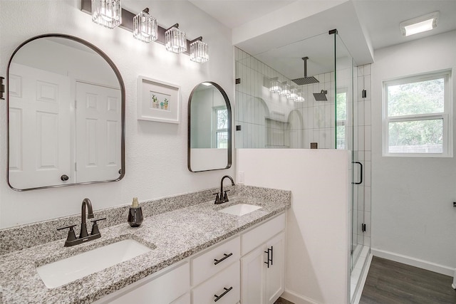 6325 Wallingford Dr, Fort Worth, TX 76133 - bathroom with a stall shower, double vanity, wood finished floors, and baseboards