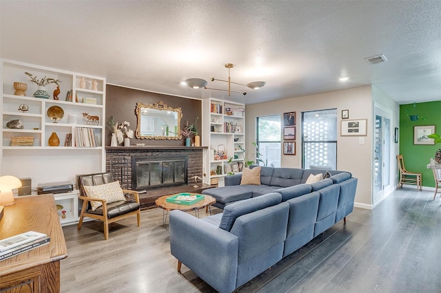6325 Wallingford Dr, Fort Worth, TX 76133 - living area featuring wood finished floors, a textured ceiling, a glass covered fireplace, and baseboards