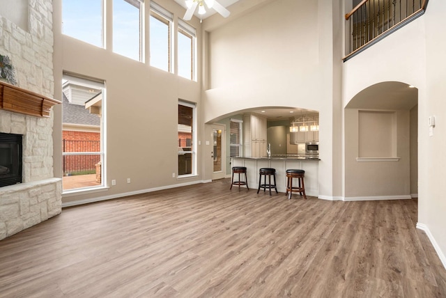 10205 Fairway Vista Dr, Rowlett, TX 75089 - unfurnished living room with a high ceiling, ceiling fan, wood finished floors, plenty of natural light, and baseboards