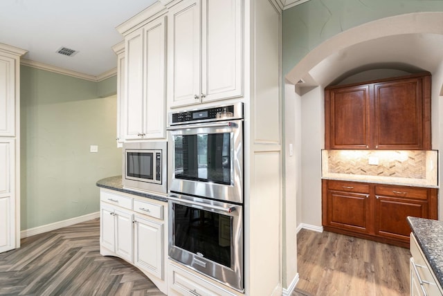 10205 Fairway Vista Dr, Rowlett, TX 75089 - kitchen with stainless steel appliances, backsplash, baseboards, ornamental molding, and dark stone counters