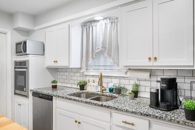 7017 Robinhood Ln, Fort Worth, TX 76112 - kitchen featuring stainless steel appliances, a sink, white cabinetry, and backsplash
