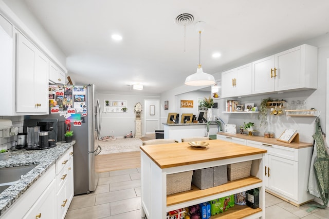 7017 Robinhood Ln, Fort Worth, TX 76112 - kitchen featuring open shelves, light tile patterned flooring, butcher block countertops, white cabinets, and recessed lighting