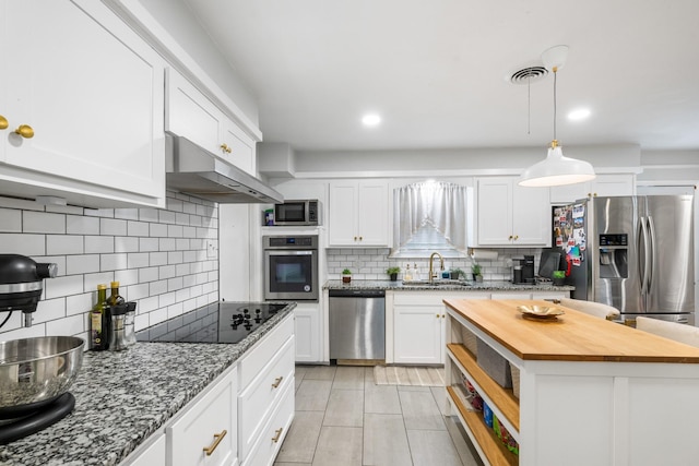 7017 Robinhood Ln, Fort Worth, TX 76112 - kitchen featuring appliances with stainless steel finishes, wood counters, a sink, tasteful backsplash, and under cabinet range hood