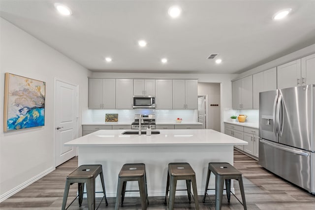 511 Rock Creek Dr, Princeton, TX 75407 - kitchen featuring appliances with stainless steel finishes, a sink, wood finished floors, backsplash, and recessed lighting