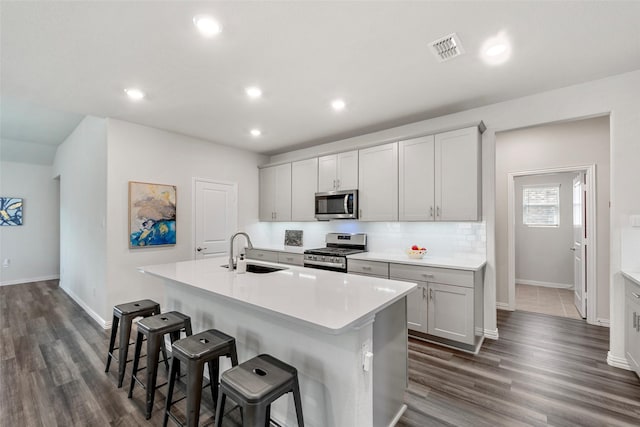 511 Rock Creek Dr, Princeton, TX 75407 - kitchen featuring stainless steel appliances, a sink, a kitchen island with sink, a breakfast bar area, and baseboards
