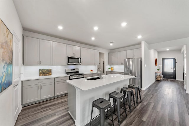 511 Rock Creek Dr, Princeton, TX 75407 - kitchen featuring stainless steel appliances, a sink, dark wood-style floors, a kitchen bar, and recessed lighting