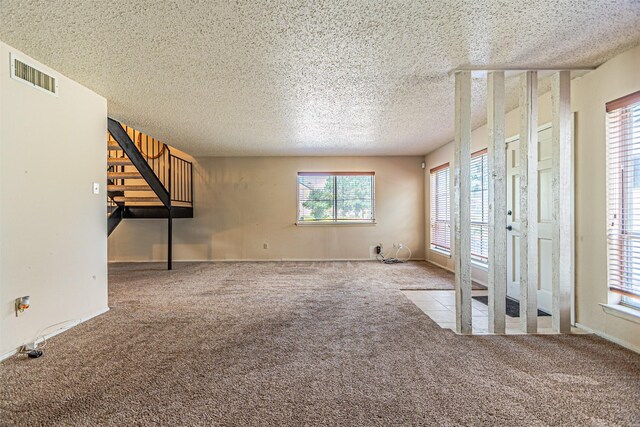 3626 Holly Tree Trl, Garland, TX 75044 - unfurnished living room with carpet floors, a textured ceiling, and stairway