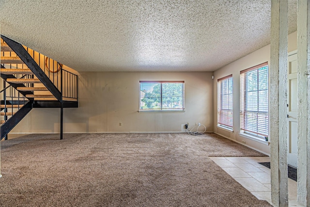 3626 Holly Tree Trl, Garland, TX 75044 - unfurnished living room with carpet, plenty of natural light, stairs, a textured ceiling, and baseboards