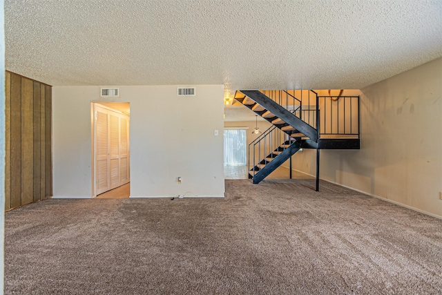 3626 Holly Tree Trl, Garland, TX 75044 - unfurnished living room with stairway, carpet flooring, and a textured ceiling
