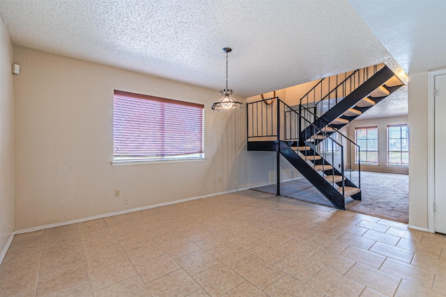 3626 Holly Tree Trl, Garland, TX 75044 - unfurnished living room featuring a textured ceiling, stairway, and baseboards