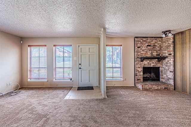 3626 Holly Tree Trl, Garland, TX 75044 - carpeted entrance foyer with a textured ceiling, a brick fireplace, and baseboards
