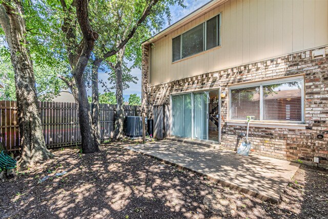 3626 Holly Tree Trl, Garland, TX 75044 - back of house featuring central AC, a patio area, and stone siding