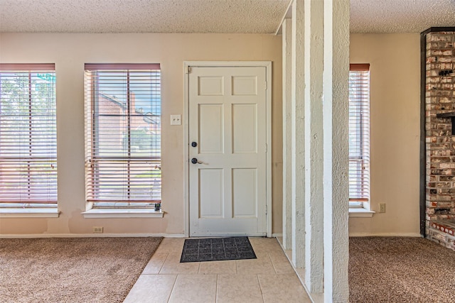 3626 Holly Tree Trl, Garland, TX 75044 - entrance foyer featuring a textured ceiling, light tile patterned floors, light carpet, and baseboards