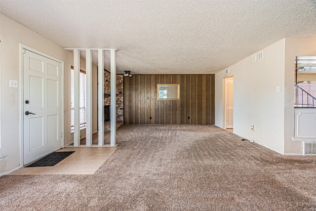 3626 Holly Tree Trl, Garland, TX 75044 - entryway with a textured ceiling, wood walls, carpet, and a brick fireplace