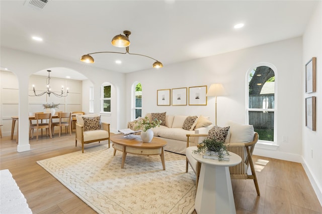15616 Terrace Lawn Cir, Dallas, TX 75248 - living area with light wood-type flooring, arched walkways, recessed lighting, baseboards, and a chandelier