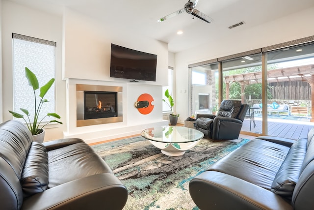 3711 Pistol Creek Dr, Frisco, TX 75034 - living room featuring a glass covered fireplace, wood finished floors, and recessed lighting