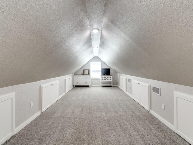 4432 Willow Ln, Dallas, TX 75244 - bonus room with a textured ceiling, light colored carpet, vaulted ceiling, and baseboards