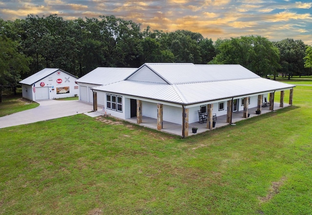632 County Road 1952, Yantis, TX 75497 - view of front facade with a yard, driveway, metal roof, a detached garage, and an outbuilding