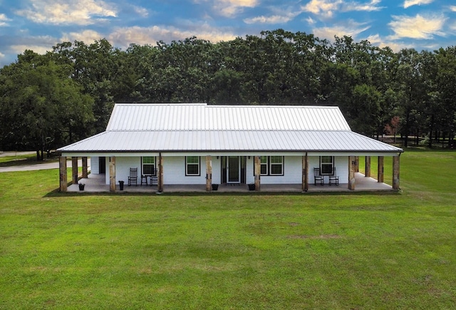 632 County Road 1952, Yantis, TX 75497 - back of house with covered porch, a lawn, and metal roof